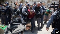Israeli police officers detain a Palestinian man outside the Lion's Gate, following an appeal from clerics to pray in the streets instead of the Al Aqsa Mosque compound, in Jerusalem's Old City, July 19, 2017.