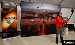 FILE - A visitor logs in front of a NASA screen at Lompoc Airport before launching a United Launch Alliance Atlas rocket carrying the NASA InSight Mars lander, taking off from Vandenberg Air Force Base in California May 5, 2018.