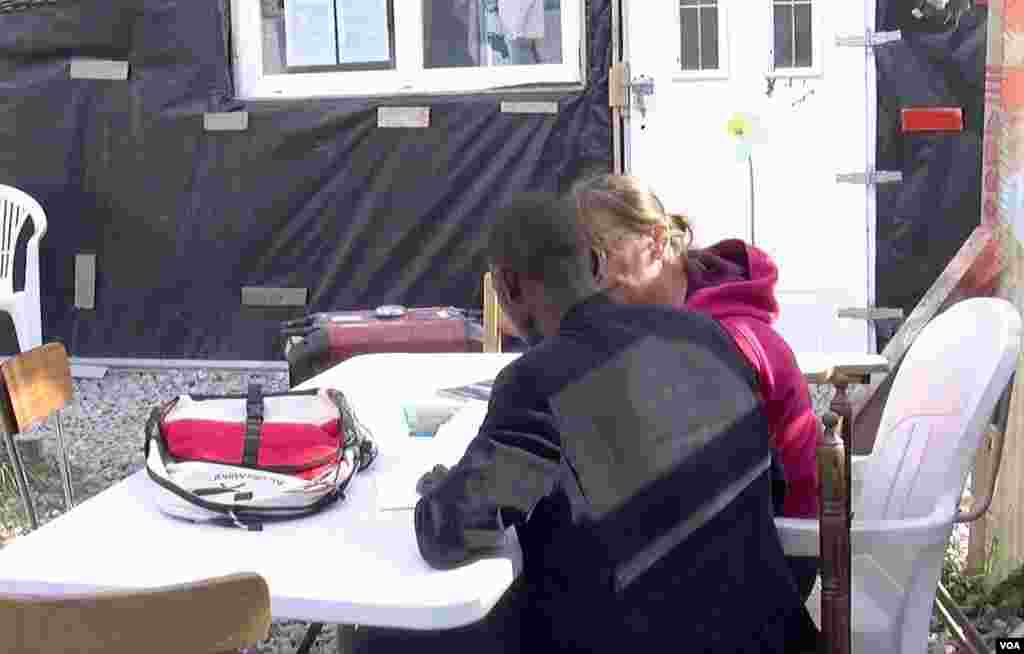 A migrant is seen studying at Zimako Jones' school, one of several makeshift schools at the Jungle camp in Calais, France. (L. Bryant/VOA)