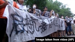 Người biểu tình mang theo hình ảnh của những người bị thương, với khuôn mặt bị rách nát vì những mảnh vỡ trong vụ nổ.