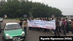 Quelques jeunes brandissent un calicot lors d’une marche de l’opposition à Brazzaville, Congo, 8 juin 2017. (VOA/Ngouela Ngoussou)