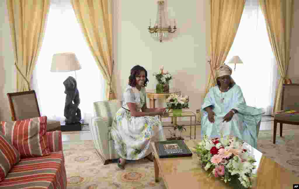 Ibu negara AS Michelle Obama dan ibu negara Senegal Mariame Faye Sall, berbincang di istana presiden di Dakar, Senegal (27/6). (AP/Carolyn Kaster)