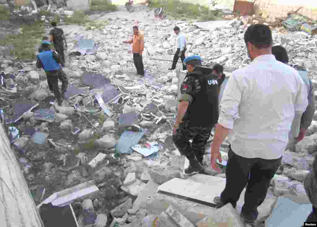 Members of the United Nations observer mission in Syria between destroyed houses in Sermeen, near the northern city of Idlib, May 15, 2012.