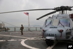 In this April 20, 2019, file photo, a U.S. marine patrols on the deck of the USS Blue Ridge, flagship of the U.S. Seventh Fleet, during a port call in Hong Kong, Saturday, April 20, 2019.