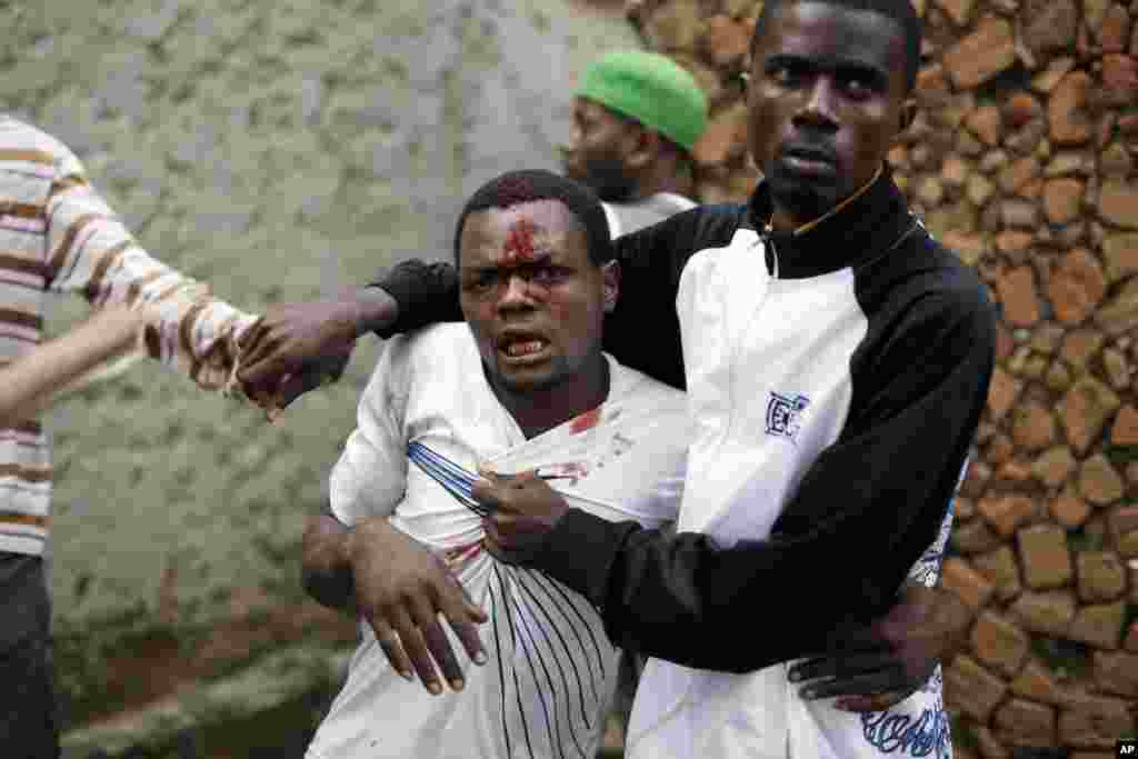 Jean Claude Niyonzima is restrained by a mob gathered around his house in Bujumbura, May 7, 2015.
