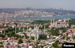 FILE - The Ottoman-era Blue Mosque and the sixth-century Byzantine monument of Hagia Sofia (Ayasofya) are seen in the old city as skyscrapers of the city's financial district stand in the background over the port of Istanbul June 1, 2007.