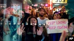 Protesters slam their hands against a bus shelter as they chant April 29, 2015, in New York. 