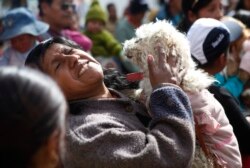 Seorang wanita dan anjingnya menghadiri Misa pada Hari Anjing, di El Alto, Bolivia, Sabtu, 16 Agustus 2014. (Foto: AP/Juan Karita)