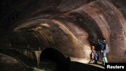 Diggers Andriy Ryshtun and Oleksandr Ivanov explore the city sewage system where dozens of Jews were hiding from the Nazis during World War Two in Lviv, Ukraine September 25, 2021. (REUTERS/Gleb Garanich)