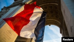 file - The French flag flies under the Arc de Triomphe.