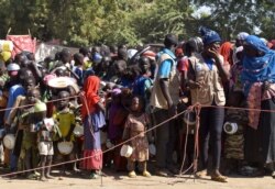 Cameroonians who fled deadly intercommunal violence between Arab Choa herders and Mousgoum and Massa farming communities queue to receive food at a temporarily refugee camp on the outskirts of Ndjamena, Chad, Dec. 13, 2021.