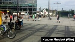 Outside the main train station in Dresden, Germany, refugees say with the long and opaque wait for documentation, they often have little to do but to wait, July 8, 2016. (H. Murdock/VOA)