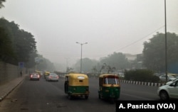Even during the day visibility is poor on the streets of New Delhi, India, due to high pollution levels, Nov. 6, 2016.