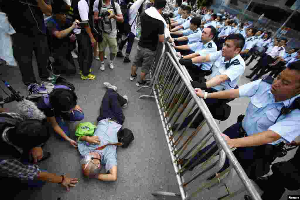 Police officers try to remove a protester from the entrance to Hong Kong's Chief Executive Leung Chun-ying offices next to the government headquarters building in Hong Kong, Oct. 2, 2014.