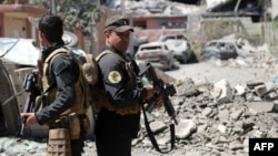 Iraqi Counter-Terrorism Services (CTS) secure a street near the old city in west Mosul on June 3, 2017, during their ongoing battle to retake the city from Islamic State (IS) group fighters.