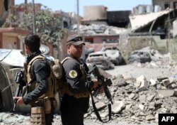 FILE - Iraqi Counter-Terrorism Services (CTS) soldiers secure a street near the Old City in west Mosul on June 3, 2017, during their ongoing battle to retake the city from Islamic State group fighters.