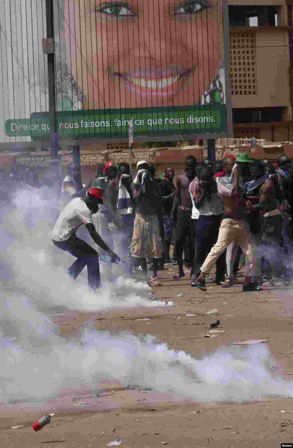 Des manifestants tentent de se couvrir du gaz lacrymogène que la police a lancé lors d&rsquo;une manifestation contre la révision constitutionnelle à Ouagadougou, Burkina Faso, le 28 octobre 2014. 
