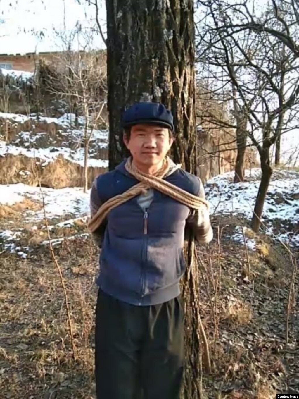 张盼成在甘肃老家村庄把自己绑在树上拍照（华涌推特照片）(photo:VOA)