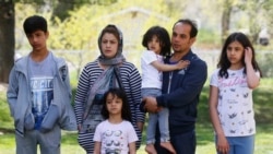 In this April 22, 2020, photo, Afghan refugee Mahmood Amiri poses for a photograph with his family, in West Valley City, Utah. The coronavirus restrictions imposed across the U.S. have affected refugee families in many of the same ways as other Americans,