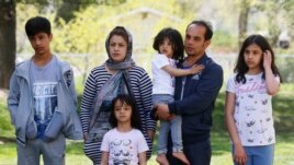 In this April 22, 2020, photo, Afghan refugee Mahmood Amiri poses for a photograph with his family, in West Valley City, Utah. The coronavirus restrictions imposed across the U.S. have affected refugee families in many of the same ways as other Americans,