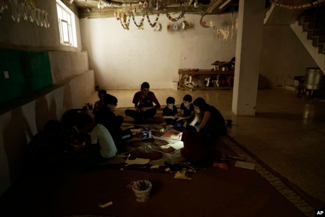 In this Aug. 22, 2018 photo, Yazidi children work on arts and crafts in the basement of an orphanage in Sheikhan, Iraq.
