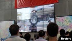 지난달 25일 중국 상하이 게임 박람회에서 방문객들이 '광명사명' 게임 영상을 보고 있다. 