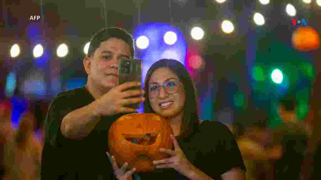 A pocos días de que inicie Halloween, una pareja posa para una fotografía durante el Festival de la Calabaza en el Parque Fundidora, México.