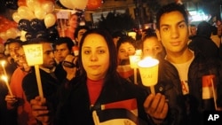 Egyptians hold lit candles during New Year's Eve in Tahrir Square, Cairo, Saturday, Dec. 31, 2011.