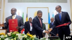 FILE - The Angolan President Joao Lourenço (C) shakes hands with Rwandan president Paul Kagame (R) next to Ugandan President Yoweri Museveni (L) after the signing an agreement to cease hostilities between Uganda and Rwanda, Aug. 21, 2019.