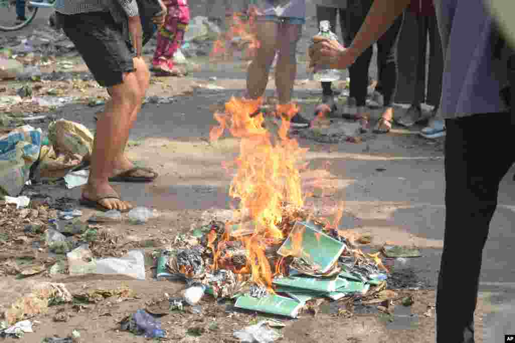 Anti-coup protesters burn constitution books at Tarmwe township in Yangon, Myanmar. Opponents of military government declared the country’s 2008 constitution void.