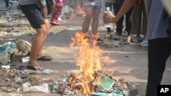 Anti-coup protesters burn constitution books at Tarmwe township in Yangon, Myanmar Thursday April 1, 2021. Opponents of Myanmar’s military government declared the country’s 2008 constitution void and put forward an interim replacement charter late…