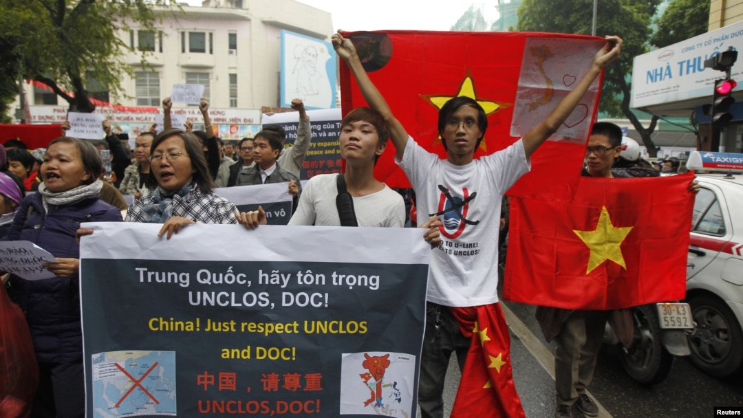 Người biểu tình chống Trung Quốc cầm quốc kỳ Việt Nam và các biểu ngữ chống Trung Quốc tuần hành trên đường phố trung tâm Hà Nội, ngày 9/12/2012. 