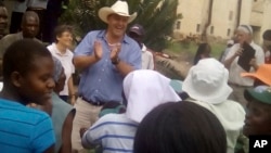 Farmer Darryn Smart, center, son of Robert Smart, and his family are welcomed back to their farm, Lesbury, by workers and community members, Dec. 21, 2017, in Tandi, Zimbabwe.