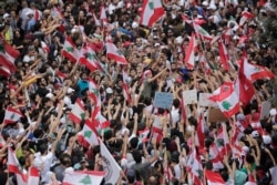 FILE - Anti-government protesters shout slogans in Beirut, Lebanon, Oct. 20, 2019.