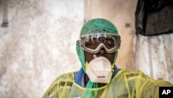 Un agent de santé couvert d'un équipement de protection, examine des patients pour Ebola sous une tente de dépistage, à l'hôpital gouvernemental de Kenema situé dans la province de l'Est à environ 300 km de la capitale de Freetown, Sierra Leone, 11 août 2014