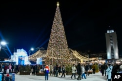 Orang-orang berkumpul di sekitar pohon Natal di pusat pelabuhan timur jauh Rusia Vladivostok, Rusia, Selasa, 31 Desember 2024, untuk merayakan tahun baru. (Foto AP)