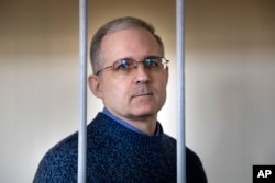 FILE - Paul Whelan, a former U.S. marine, who was arrested for alleged spying in Moscow at the end of 2018, stands in a cage while waiting for a hearing in a court room in Moscow, Russia, Aug. 23, 2019.