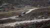 FILE - An Indian Army truck drives along a road to Tawang, near the Line of Actual Control (LAC), neighboring China, near Sela Pass in India's Arunachal Pradesh state, Oct. 21, 2021.