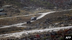 FILE - An Indian Army truck drives along a road to Tawang, near the Line of Actual Control (LAC), neighboring China, near Sela Pass in India's Arunachal Pradesh state, Oct. 21, 2021.