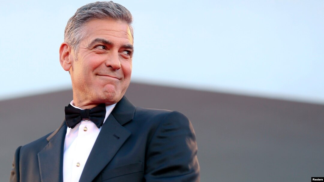 U.S. actor George Clooney smiles as he arrives on the red carpet for the premiere of "Gravity" at the 70th Venice Film Festival in Venice, August 28, 2013. 
