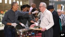 ປະທານາທິບໍດີ ທ່ານ ບາຣັກ ໂອບາມາ ພ້ອມກັບສະຕີໝາຍເລກໜຶ່ງ ທ່ານ ໂມແຊລ ໂອບາມາ ແລະ ພີ່ນ້ອງບາງຄົນ ເສີບອາຫານວັນ Thanksgiving ໃຫ້ກັບ ຜູ້ທີ່ອາໄສຢູ່ໃນເຮືອບຜູ້ກິນເບ້ຍບຳນານຂອງ ກອງທັບ ໃນນະຄອນຫຼວງ ວໍຊິງຕັນ. 23 ພະຈິກ, 2016.