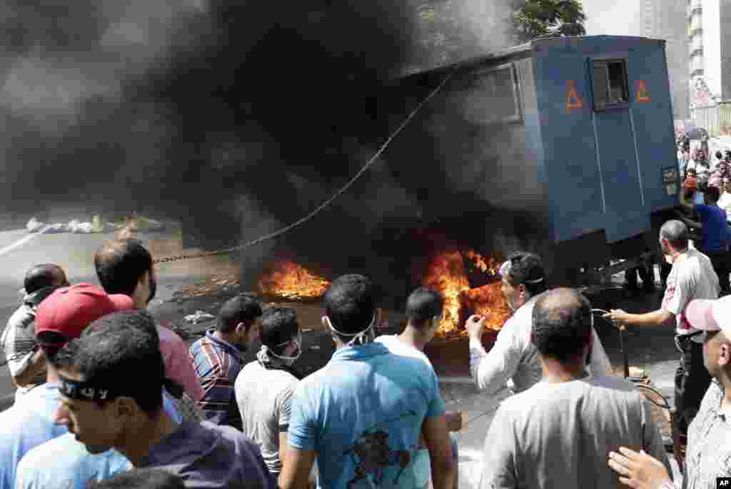 Supporters of ousted Islamist President Mohammed Morsi surround a burning police car during clashes with Egyptian security forces in Cairo&#39;s Mohandessin neighborhood, Egypt, &nbsp;August 14, 2013.&nbsp;