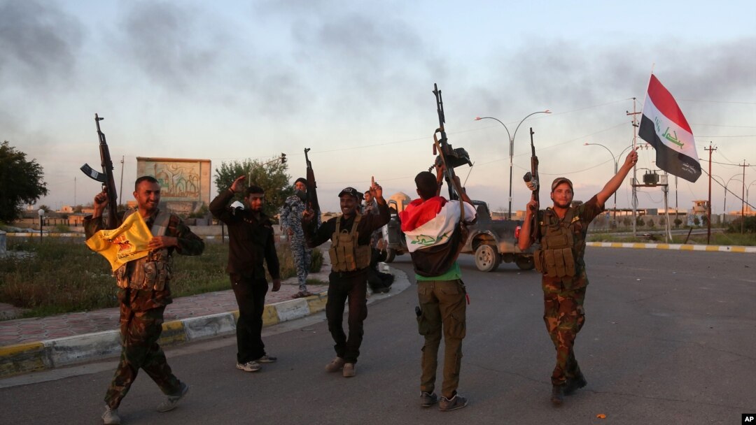 Iraqi security forces and allied Shi'ite militiamen celebrate in central Tikrit, 80 miles (130 kilometers) north of Baghdad, March 31, 2015.