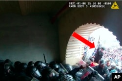 This image from video from the U.S. Justice Department contained in the sentencing memorandum, and annotated by the source, shows David Nicholas Dempsey throwing a pole at a police officer in the Lower West Terrace Tunnel at the U.S. Capitol on Jan. 6, 2021, in Washington.