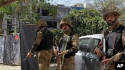 Pakistani soldiers stand alert at the site of an explosion, in Lahore, Pakistan, Thursday, Feb. 23, 2017. A Pakistani provincial minister says an explosion has killed at least eight people in the eastern city of Lahore. 