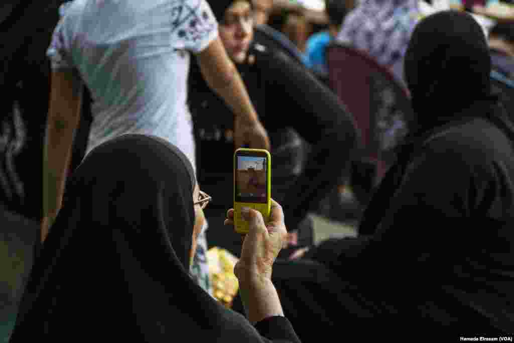 An elderly muslim woman films Amru Ebn Alaas mosque with her phone in old Cairo, Egypt, June 21, 2017. (Hamada Elrasam/VOA)