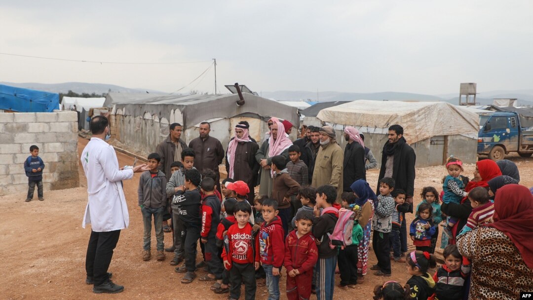 A doctor talks with refugees at a camp for displaced people in Atme, in Syria's northwestern Idlib province, near the border with Turkey, March 14, 2020. 
