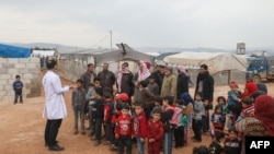 A doctor talks with refugees at a camp for displaced people in Atme, in Syria's northwestern Idlib province, near the border with Turkey, March 14, 2020. 