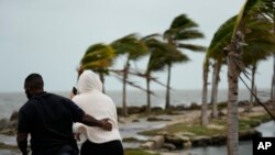 ARCHIVO: Dos personas desafían condiciones de tormenta en Coral Gables, Florida, el 15 de diciembre de 2023.