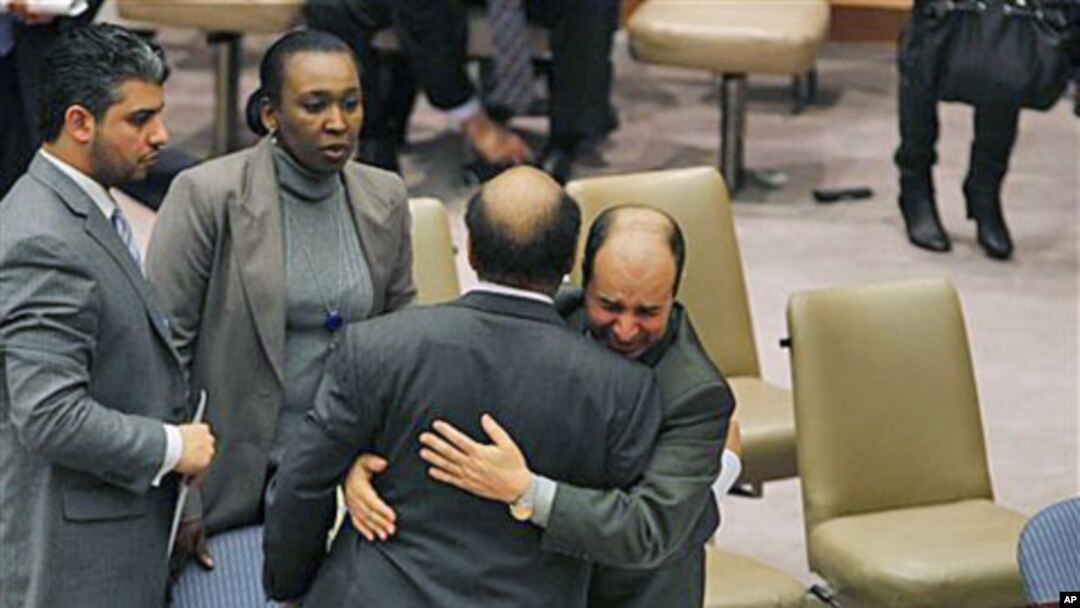 Libya's deputy UN ambassador Ibrahim Dabbashi, right, hugs Libya's UN ambassador Mohamed Shalgham after a meeting of the Security Council at United Nations headquarters in New York, February 25, 2011